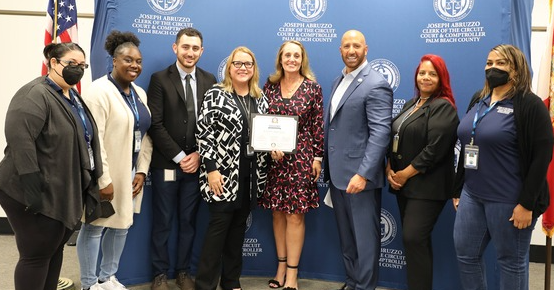 Clerk Abruzzo with a group of employees holding a Best Practices award