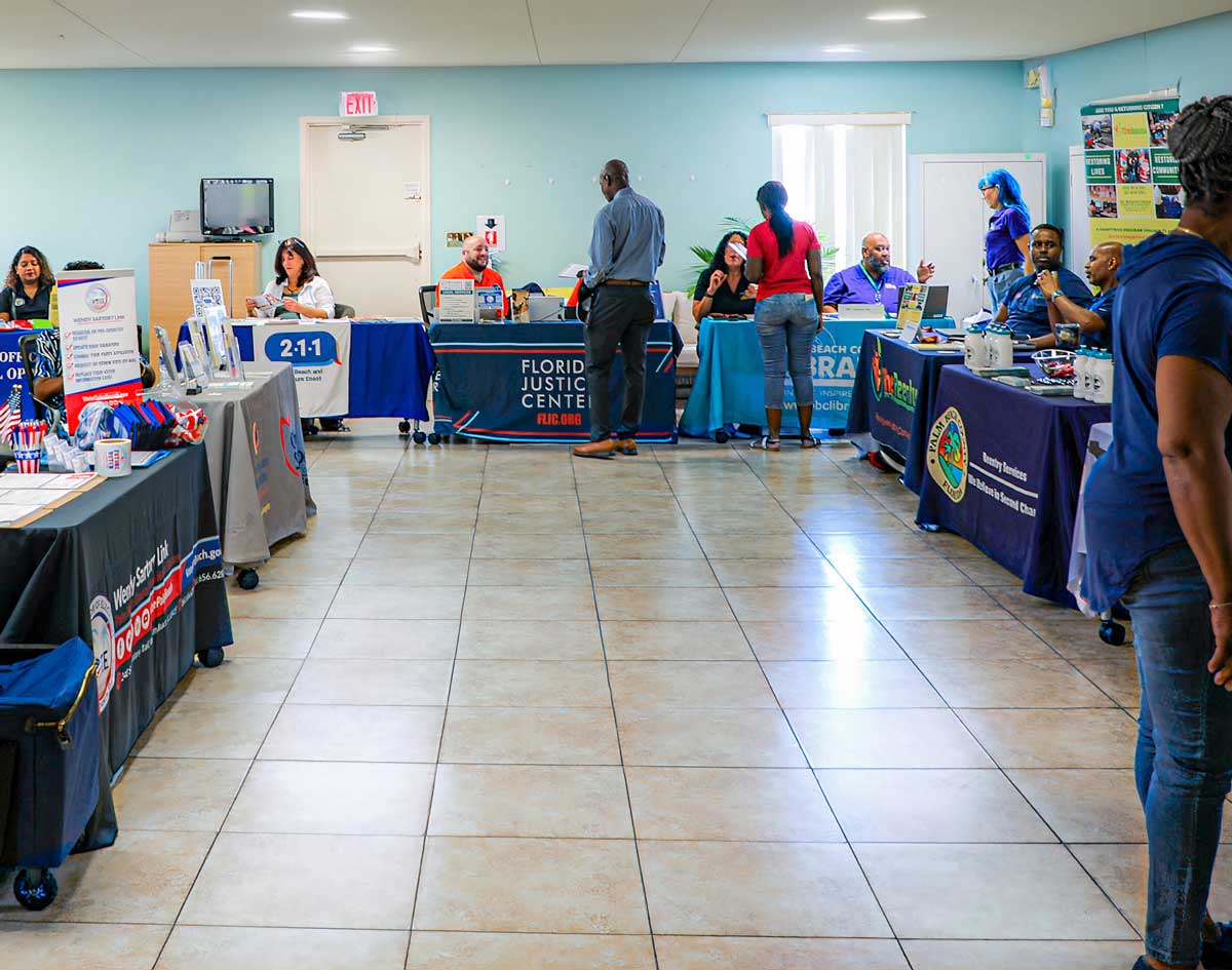 people at tables at the community resource fair